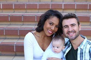 Happy Young Attractive Mixed Race Couple with Newborn Baby with